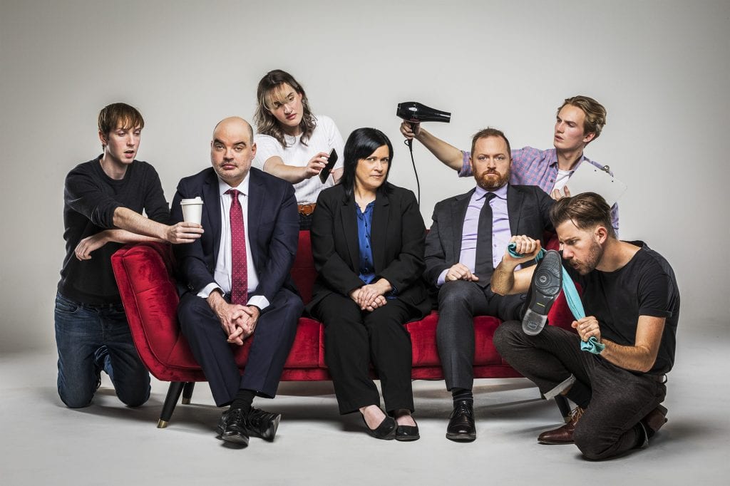Editorial promotional studio photography of The Chaser 7 people seated on red couch