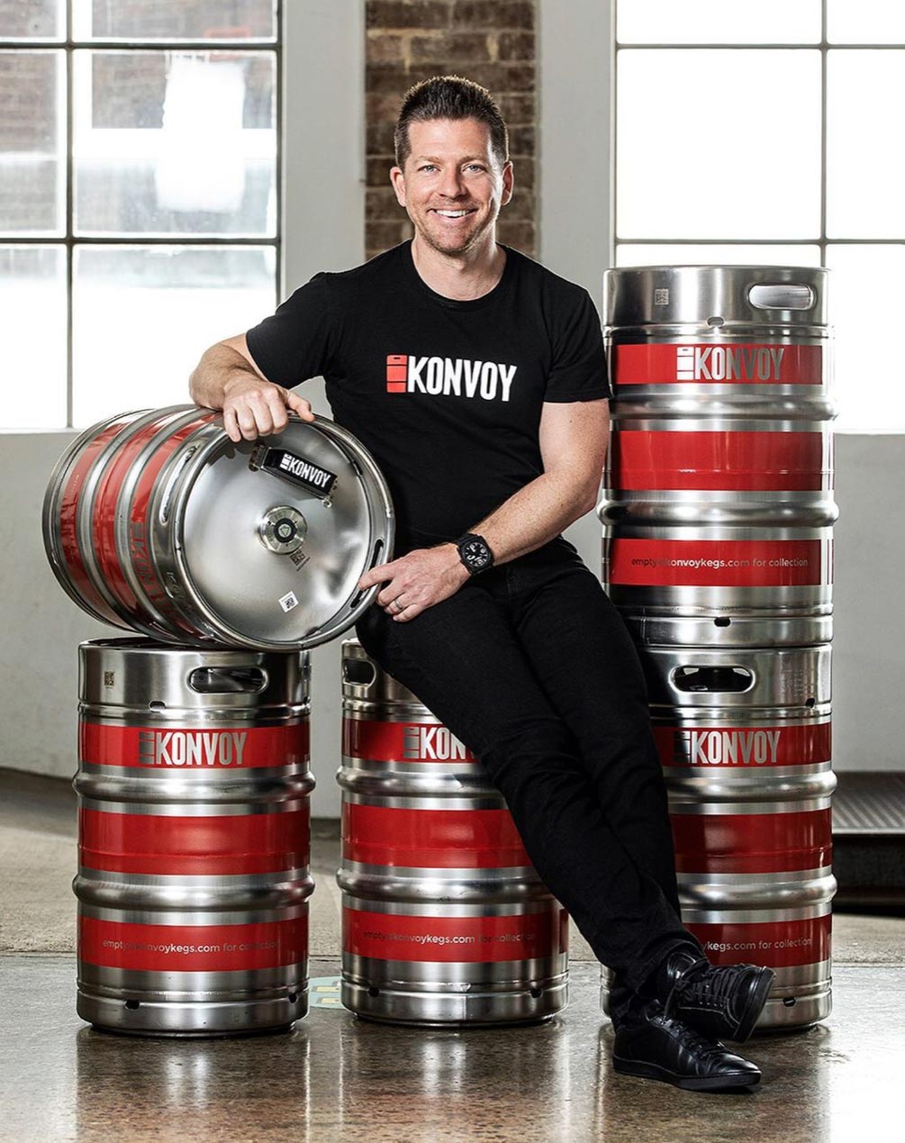 Editorial portrait photography Managing Director & Founder of KPNVOYAdam Trippe-Smith sitting on beer kegs